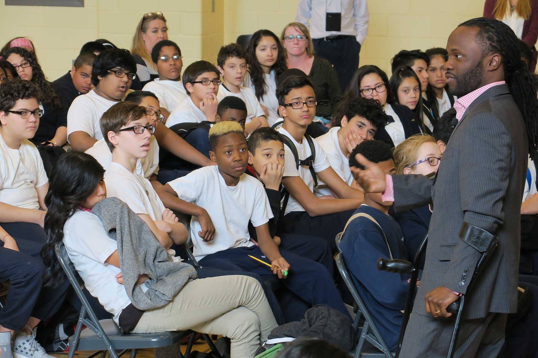 Hashim speaking to seated students in a classroom