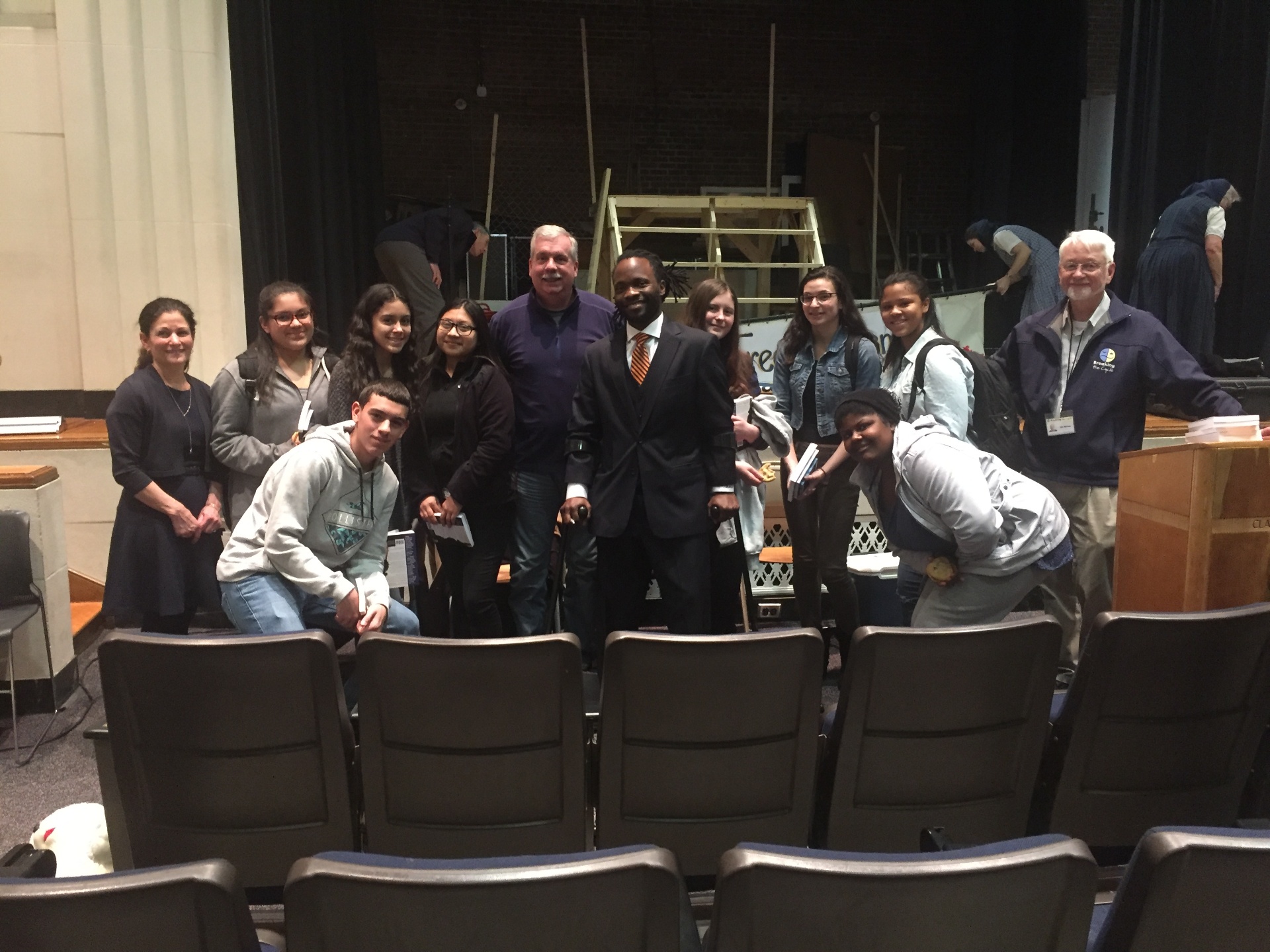 Student group with Hashim on a theater stage